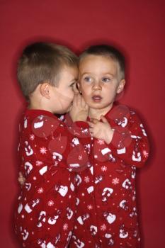 Royalty Free Photo of a Twin Whispering to His Twin
