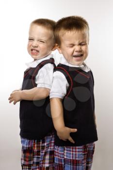 Royalty Free Photo of Twin Boys Crying Standing Back to Back