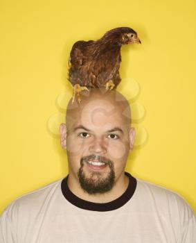 Royalty Free Photo of a Man With a Golden Laced Wyandotte Chicken on His Head