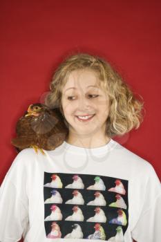 Royalty Free Photo of a Woman Looking at a Chicken on Her Shoulder