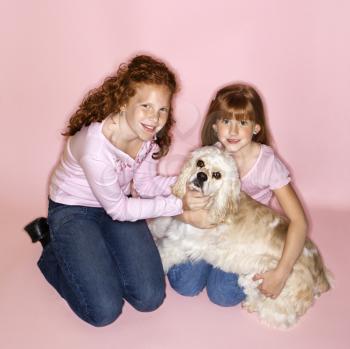 Royalty Free Photo of Female Children Holding a Cocker Spaniel Dog