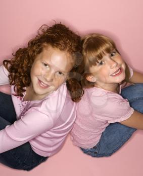 Royalty Free Photo of Little Girls Sitting Back to Back