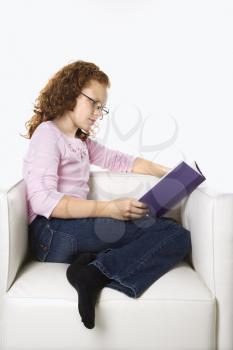 Royalty Free Photo of a Little Girl Sitting Reading a Book