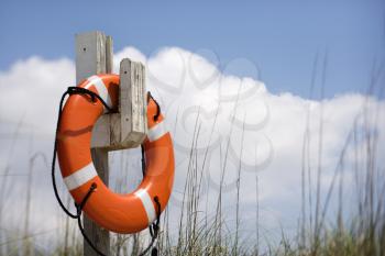 Royalty Free Photo of a Life Preserver Hanging on a Post on a Beach in Bald Head Island, North Carolina
