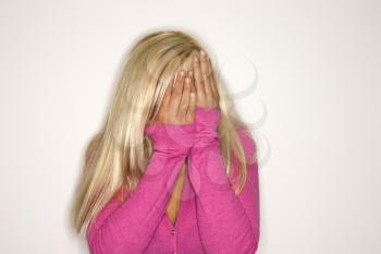 Royalty Free Photo of a Portrait of a Blonde Woman Covering Her Face With Her Hands
