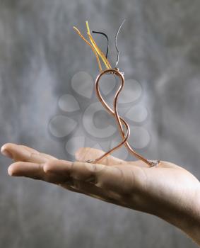 Royalty Free Photo of a Hand Holding a Wire Sculpture