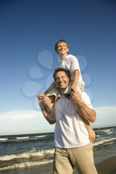 Royalty Free Photo of a Son Sitting on His Father's Shoulders