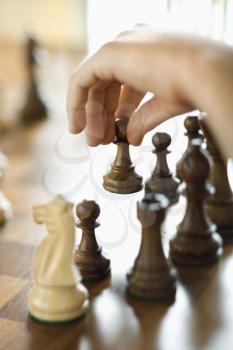 Royalty Free Photo of a Hand Moving a Chess Piece