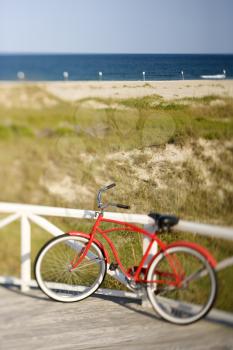 Royalty Free Photo of a Red Bike Leaning Against a Railing
