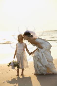 Royalty Free Photo of a Bride Kneeling to Give the Flower Girl a Kiss on the Cheek