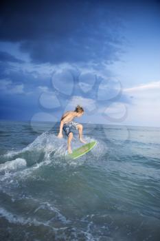 Royalty Free Photo of a Teen Riding a Skimboard