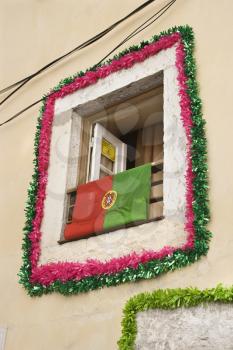 Royalty Free Photo of a Window Decorated With Garland and Flag in Lisbon, Portugal