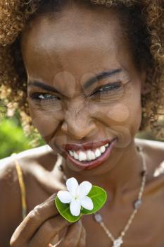 Royalty Free Photo of a female squinting and holding jasmine flower