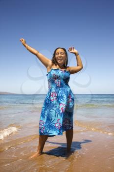 Royalty Free Photo of a Woman Standing in the Shore With Her Arms Outstretched
