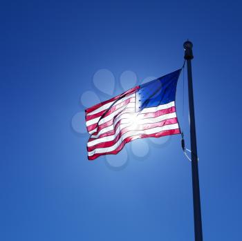 Royalty Free Photo of an American Flag Blowing in the Clear Blue Sky