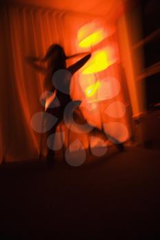 Royalty Free Photo of a Blurred Woman Silhouetted by a Floor Lamp