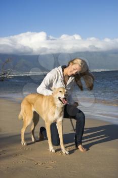 Royalty Free Photo of a Woman Petting a Dog on a Leash on Maui, Hawaii Beach