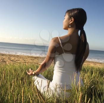 Royalty Free Photo of a Woman Meditating on a Beach