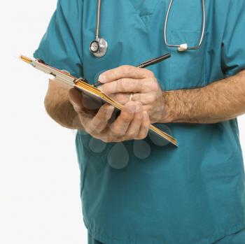 Royalty Free Photo of a Doctor in Scrubs Making Notes on a Patient's Chart