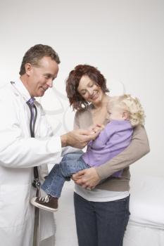 Royalty Free Photo of a Male Doctor Comforting a Mother and Daughter