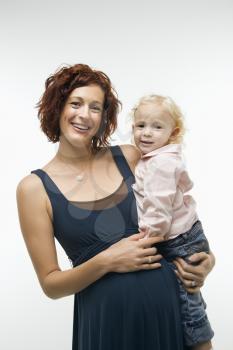 Royalty Free Photo of a Pregnant Woman Standing Holding Her Daughter