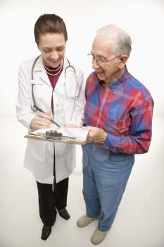 Mid-adult Caucasian female doctor showing papers to elderly Caucasian male.