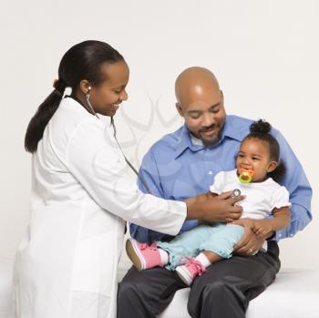 Royalty Free Photo of a Father Holding His Daughter Talking to a Pediatrician
