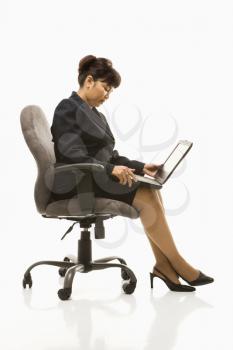 Royalty Free Photo of a Businesswoman Sitting in a Office Chair With a Laptop