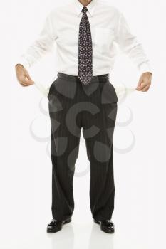 Royalty Free Photo of a Caucasian Businessman Pulling Empty Pockets Out Standing