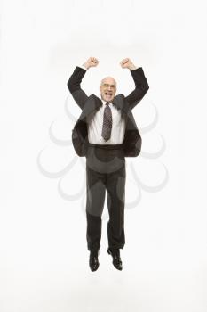 Royalty Free Photo of a Smiling Businessman Jumping With Arms Raised