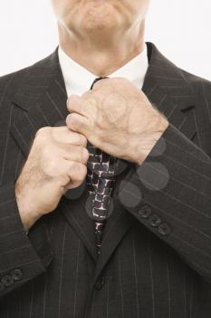 Royalty Free Photo of a Businessman Straightening His Tie