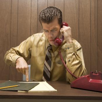 Royalty Free Photo of
a Businessman Talking on a Telephone Looking Angry