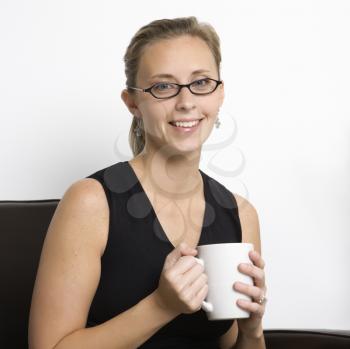 Royalty Free Photo of a Woman Wearing Eyeglasses Holding a Coffee Cup
