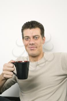 Royalty Free Photo of a Man Holding a Coffee Cup