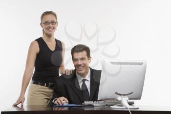 Royalty Free Photo of a Woman Touching a Man's Shoulder at a Computer