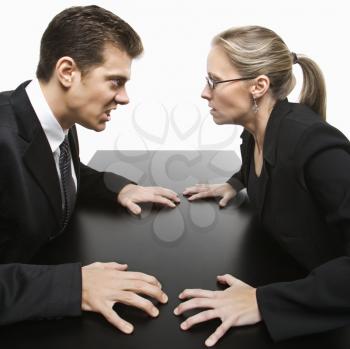 Royalty Free Photo of a Businessman and Businesswoman Staring at Each Other With Hostile Expressions