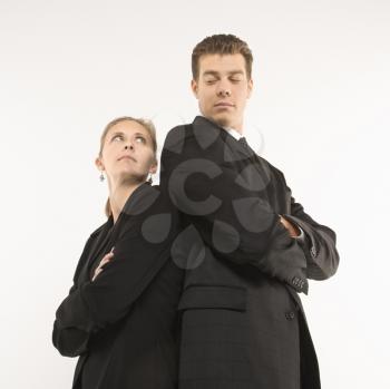 Royalty Free Photo of a Businessman and Businesswoman Standing Back to Back Looking at Each Other