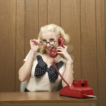 Royalty Free Photo of a Female Dressed in a Retro Outfit Holding a Red Phone Receiver 