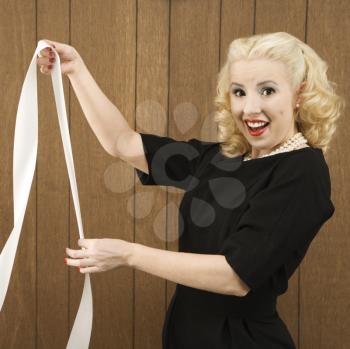 Royalty Free Photo of a Woman Wearing a Vintage Outfit Holding a Printout with Both Hands