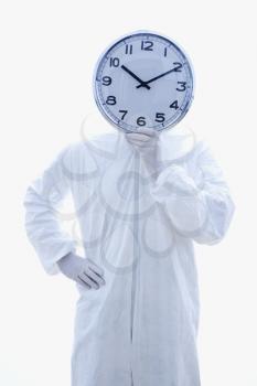Royalty Free Photo of Man in a Biohazard Suit Holding a Clock in Front of His Face