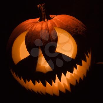 Royalty Free Photo of a Carved Halloween Pumpkin Glowing in the Dark