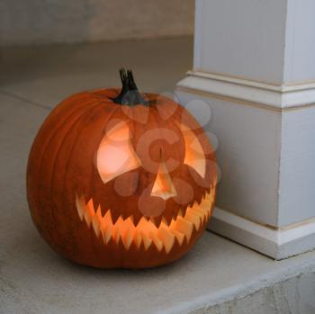 Royalty Free Photo of a Carved Halloween Pumpkin Sitting on a Doorstep