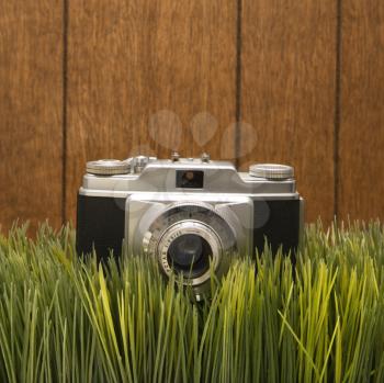 Royalty Free Photo of a Vintage Camera With Wood Paneling in the Background