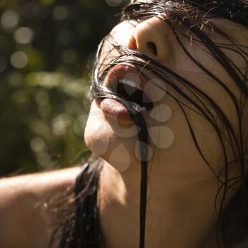 Royalty Free Photo of an Asian Woman's Face With Wet Hair Across It