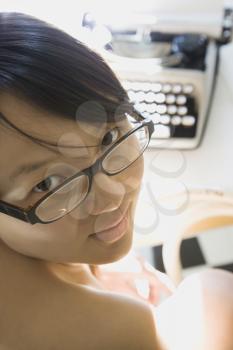 Royalty Free Photo of a Young Woman Looking Over Her Shoulder With a Typewriter in the Background
