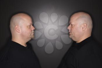 Royalty Free Photo of Twin Men Standing Face to Face