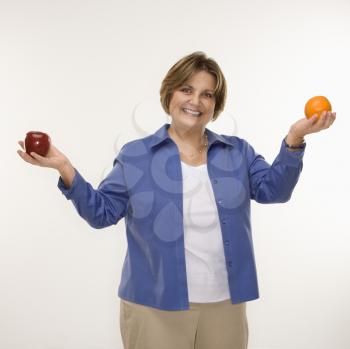 Royalty Free Photo of a Woman Holding Fruit in Outstretched Arms