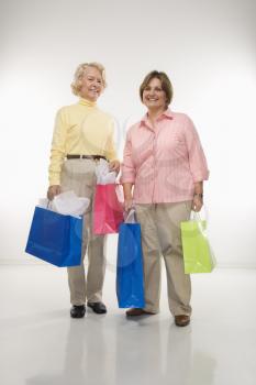Royalty Free Photo of a Senior Woman and Middle-aged Woman Holding Gift Bags and Smiling