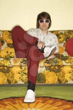 Royalty Free Photo of a Man Sitting on a Retro Sofa Wearing Sunglasses