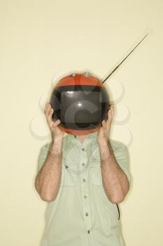 Royalty Free Photo of a Man Holding a Retro Television in Front of His Face